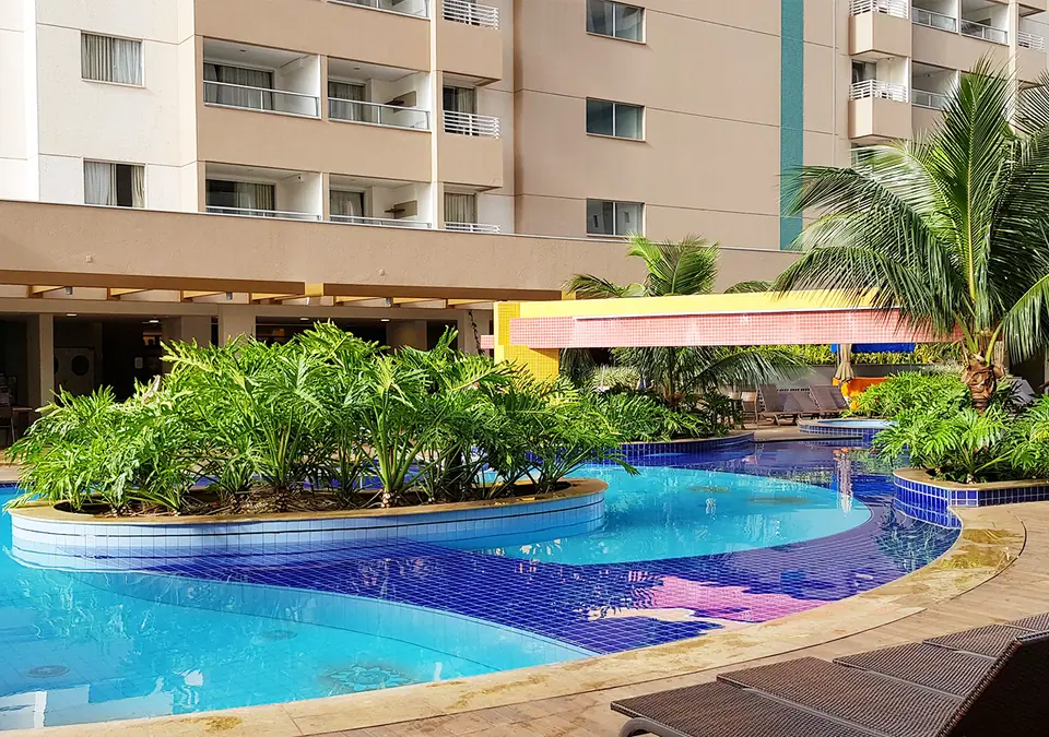 Piscinas com ilha de vegetação tropical no Enjoy Olímpia Park Resort