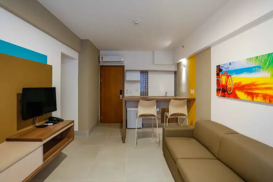 Sala com Smart TV e sofá em suíte do Enjoy Olímpia Park Resort